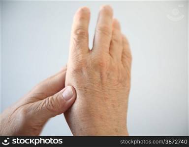a senior man experiencing soreness in his hand
