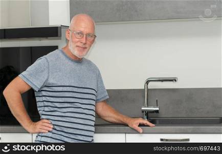 a senior man standing in the kitchen