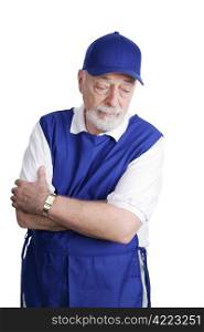 A senior man unable to retire is sad about working a menial service job. Isolated on white.