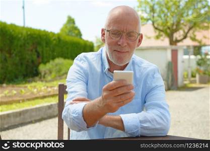 a senior man using the mobile phone outside