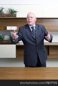 A senior manager, gesturing wildly with his hand, appearing persuasive