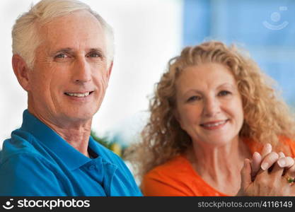 A senior retired man and woman couple holding hands and happy together.