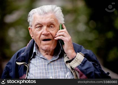 A senior talking on a cell phone outdoors