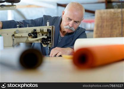 a senior upholsterer sewing cover