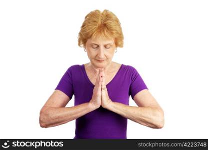 A senior woman in her seventies beginning her yoga routine by deep breathing. Isolated on white.