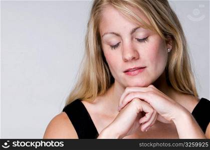 A serene blonde woman with eyes closed.
