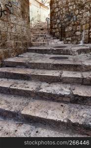 A series of steps climbs up a hill between buildings in the Arab Quarter of the Old City of Jerusalem in Israel.