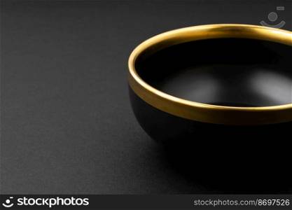 A set of black and golden ceramic plate on a black background. Set of black and golden ceramic plate on a black background