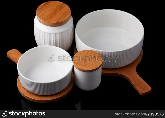 a set of porcelain and wooden utensils, on a black background.