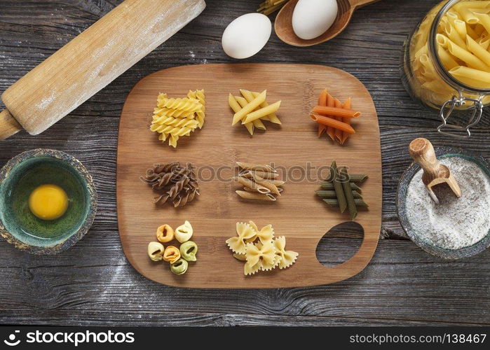 A set of raw pasta on a wooden desk. A set of raw pasta on a wooden table. Studio Shot