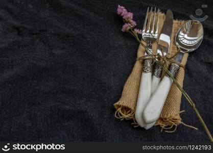 A set of Rustic vintage set of cutlery knife, spoon, fork on black background. Copy space, Selective focus.