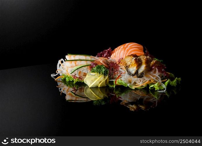 a set of sushi with shrimps on a black background with reflection. sushi on black background