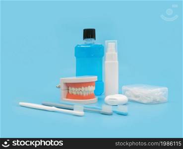 A set of tooth cleaning aid objects for mouth isolated on blue. Brushing and flossing. Dentistry. Dental health. Hygiene.