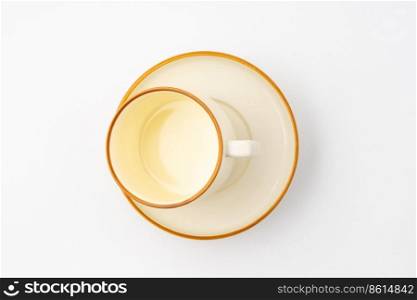A set of white and brown ceramic plate and cup on a white background. Top view. Set of white and brown ceramic plate and cup on a white background