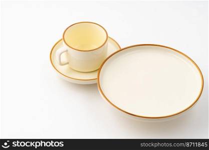 A set of white and brown ceramic plate and cup on a white background. Set of white and brown ceramic plate and cup on a white background