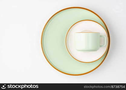 A set of white and pastel green ceramic tableware with orange outlines. Set of white and pastel green ceramic tableware with orange outlines