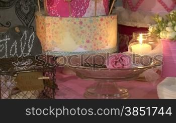 A set with chocolate biscuits, flowers, cake pops and candles. Wedding accessories in a soft, elegant and pink presentation.Decoration for a celebration: a special event, a party or a birthday.Saint Valentine&acute;s day stuff. St. Valentine&acute;s biscu