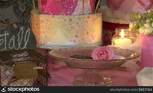 A set with chocolate biscuits, flowers, cake pops and candles. Wedding accessories in a soft, elegant and pink presentation.Decoration for a celebration: a special event, a party or a birthday.Saint Valentine&acute;s day stuff. St. Valentine&acute;s biscu