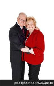 A seventies year old couple standing isolated for white background, huggingeach other in a suit and red jacket, isolated for white background.