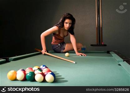 A sexy and beautiful hispanic woman playing pool