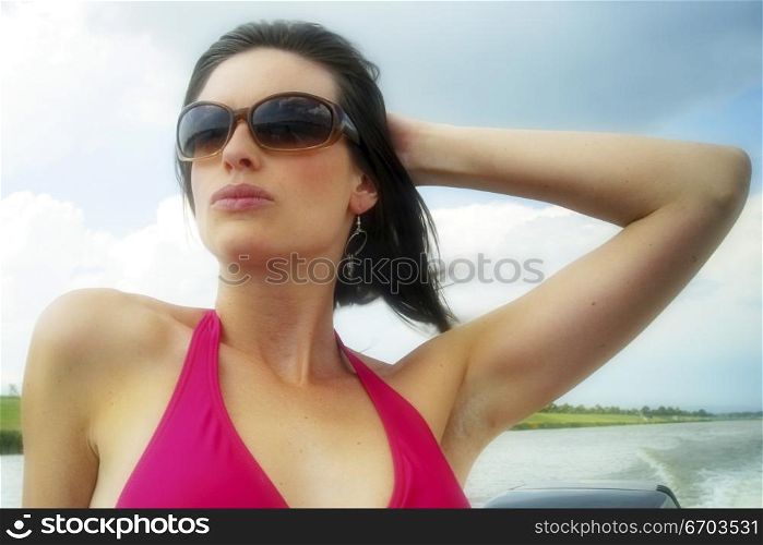 A sexy woman enjoying a summer day on her speedboat and doing water sports.