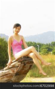 A sexy young Chinese model wears pink and poses by the sea.