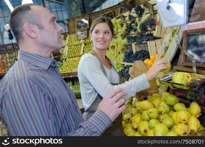 a shop assistant weighing lemons