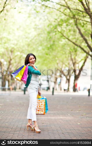 A shopping black woman carrying shopping bags outdoor