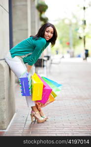 A shopping black woman carrying shopping bags outdoor