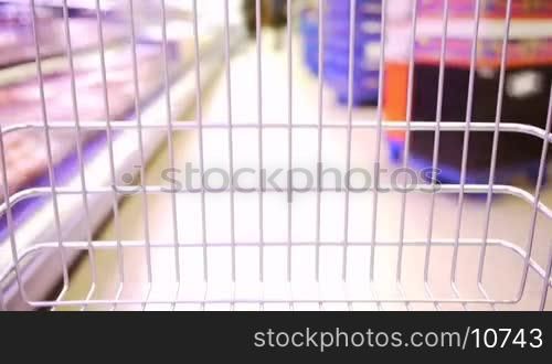 a shopping cart moves very fast in a supermarket, ein Einkaufswagen fahrt durch Zeitraffer erzeugt rasend schnell durch einen Supermarkt