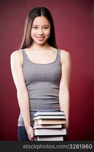 A shot of a beautiful asian college student carrying books