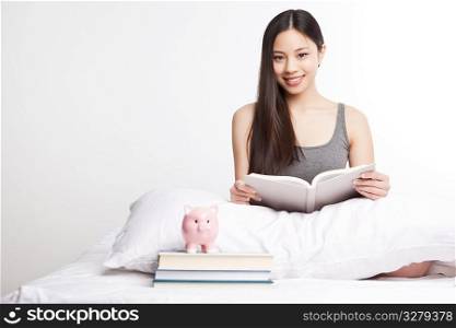 A shot of a beautiful asian college student reading on her bed