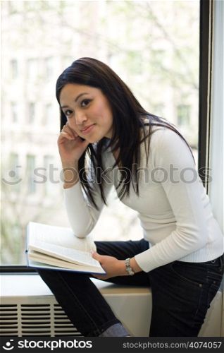 A shot of a beautiful asian college student studying in a library