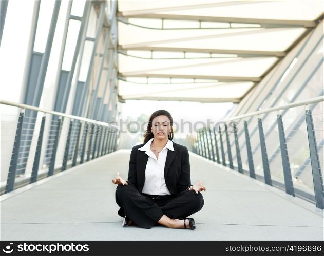 A shot of a beautiful black businesswoman meditating