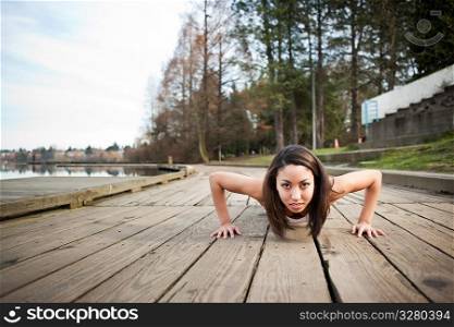 A shot of a beautiful black woman doing push up outdoor