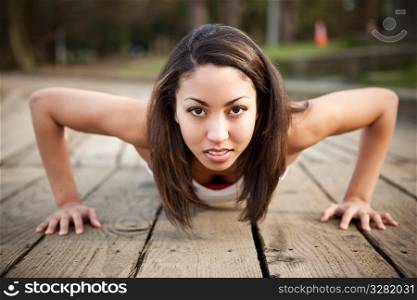 A shot of a beautiful black woman doing push up outdoor