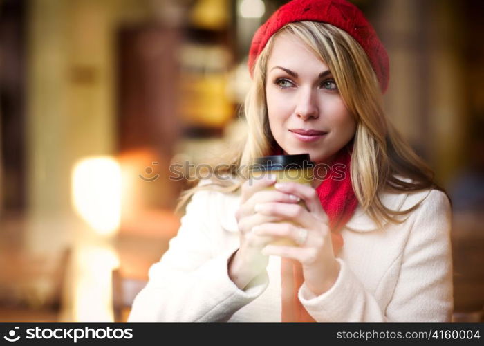 A shot of a beautiful caucasian woman drinking coffee at a cafe