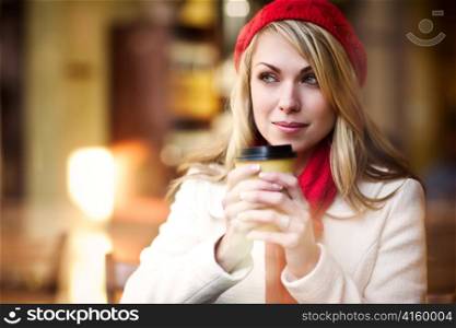 A shot of a beautiful caucasian woman drinking coffee at a cafe