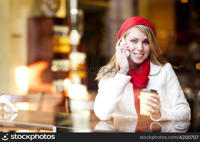 A shot of a beautiful caucasian woman talking on the phone at a cafe