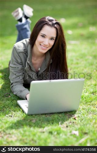 A shot of a beautiful ethnic college student working on her laptop on campus