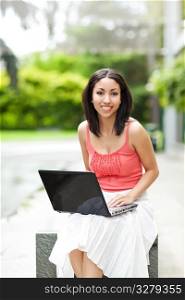 A shot of a beautiful mixed race woman with her laptop outdoor