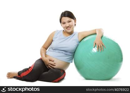 A shot of a beautiful pregnant woman with an exercise ball