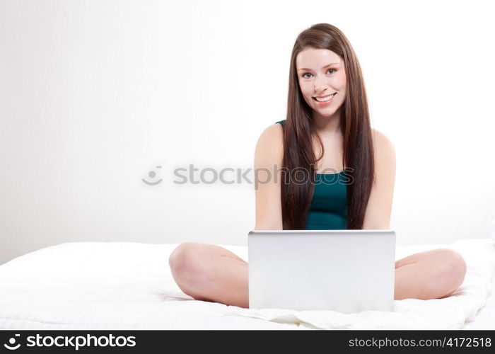 A shot of a caucasian woman with laptop on her bed