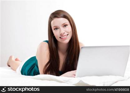A shot of a caucasian woman with laptop on her bed