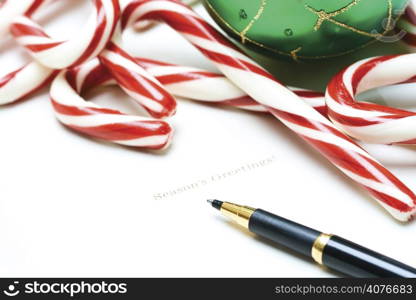A shot of a christmas greeting card with candy canes and christmas ornament