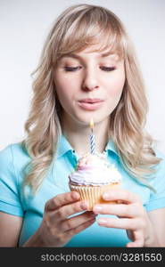 A shot of a girl celebrating her birthday blowing the candle