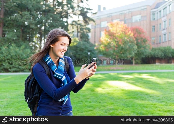 A shot of a mixed race girl texting on the phone at campus