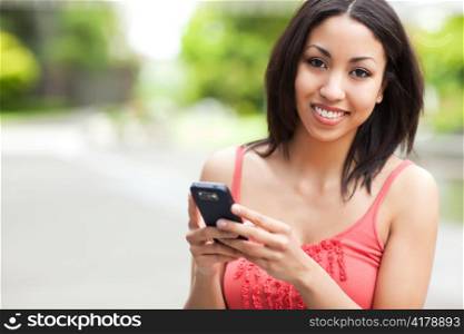 A shot of a mixed race woman texting on her cell phone