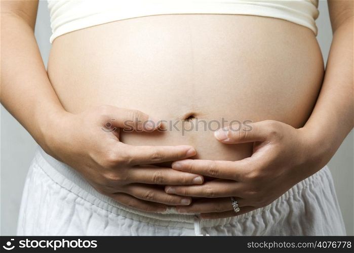 A shot of a pregnant woman holding her stomach