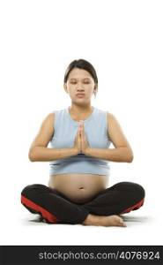 A shot of a pregnant woman meditating